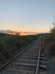 Via de tren abandonada en la puesta del sol