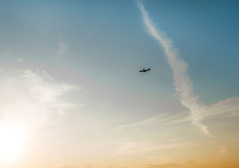 Plane over the horizon. Sunset sky. 