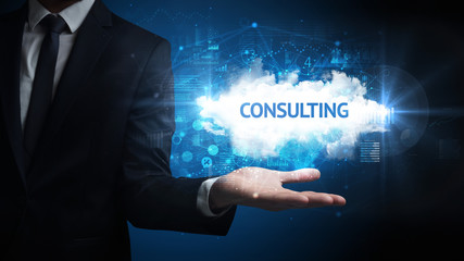 Hand of Businessman holding CONSULTING inscription, successful business concept