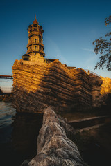 A lighthouse and an abandoned ship in the Golden rays of the sun.