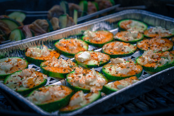 Zucchinischeiben mit Feta überbacken und Schweinelendchen Spieße auf einem Kohlegrill
