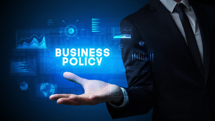 Hand of Businessman holding BUSINESS POLICY inscription, business success concept