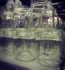 Empty glass jars stand in a row.