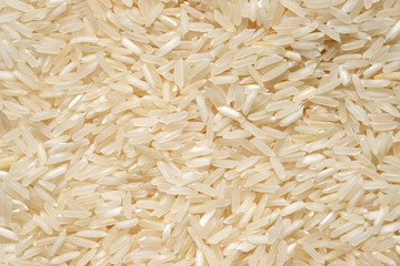 Long grain rice top view. Dry white rice grains close up background. Special rice for cooking pilaf.