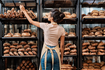 Young adult woman standing near fresh baked bread
