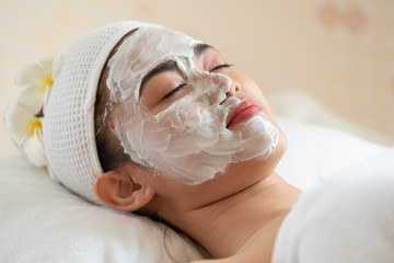 Beautiful Asian woman in mask on face in spa beauty salon, enjoying and relaxing time, skin care and healthcare concept