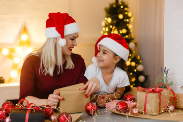 Obraz na płótnie Canvas holidays, presents, christmas, x-mas, birthday concept - happy mother and child girl with gift box