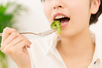 ブロッコリーを食べる女性の口元