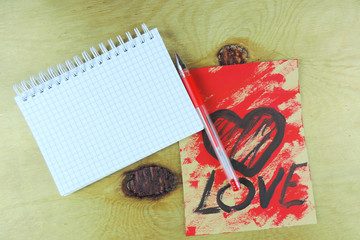 notebook for notes, space for text, card with a drawn heart, wooden surface, mock up       