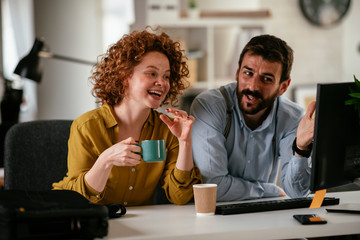 Colleagues in office. Businesswoman and businessman discussing work while drinking coffee..