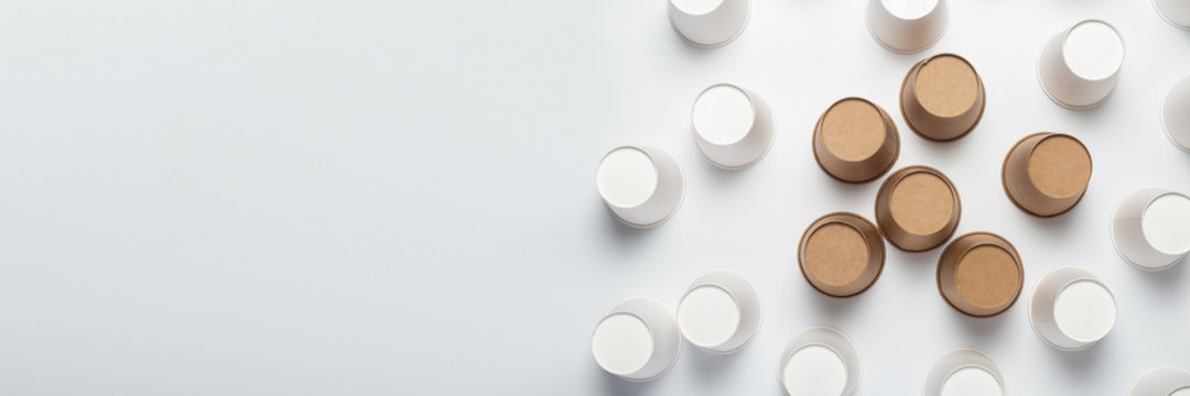 White And Brown Paper Cups Flipped Upside Down On A Light Background. Top View, Flat Lay. Banner