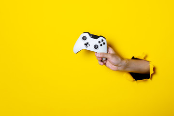 Man's hand holding a stick on a bright yellow background