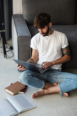 Handsome young bearded man using laptop computer