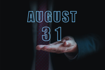 august 31st. Day 31of month, announcement of date of  business meeting or event. businessman holds the name of the month and day on his hand.. summer month, day of the year concept