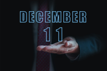 december 11th. Day 11 of month, announcement of date of  business meeting or event. businessman holds the name of the month and day on his hand.. winter month, day of the year concept