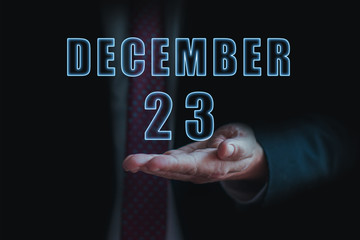 december 23rd. Day 23 of month, announcement of date of  business meeting or event. businessman holds the name of the month and day on his hand.. winter month, day of the year concept