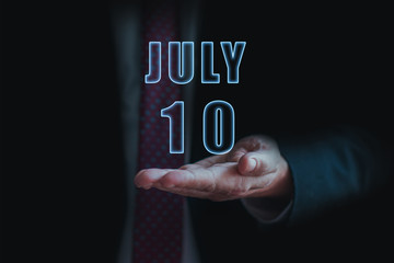 july 10th. Day 10 of month, announcement of date of  business meeting or event. businessman holds the name of the month and day on his hand.. summer month, day of the year concept