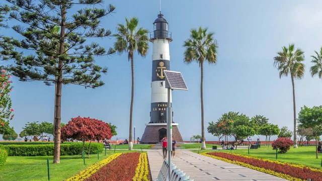 Lighthouse monument in the Park of Love of Miraflores timelapse hyperlapse. Green lawn with flowers and palms. Coastline park in nice sunny day. Lima, Peru