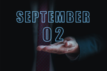 september 2nd. Day 2 of month, announcement of date of business meeting or event. businessman holds the name of the month and day on his hand. autumn month, day of the year concept