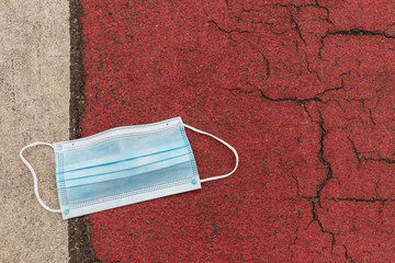 Used medical protective mask thrown on the floor.