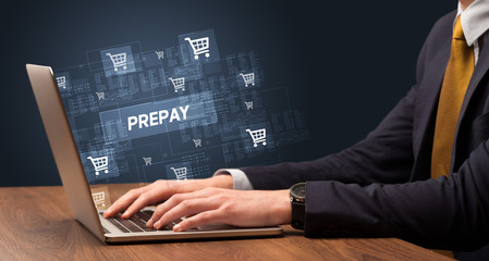 Businessman working on laptop with PREPAY inscription, online shopping concept