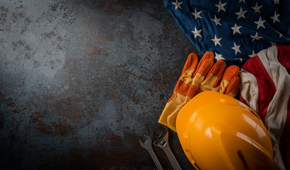 Happy Labor day concept. American flag with different construction tools on dark stone background,...