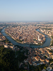 Aerial view of Arno river bend in Florence city, bridges over river, narrow streets, houses with tiled orange roofs, old town squares, italian architecture. Historic centre of Firenze Tuscany Italy