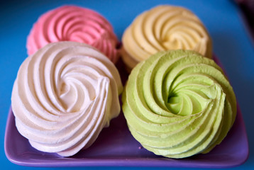 Four multi-colored cakes on a purple plate