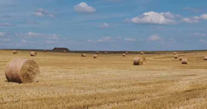 panorama among harvested rye and wheat fields with Hay bales in summer day with beautiful cirrocumilus clouds 