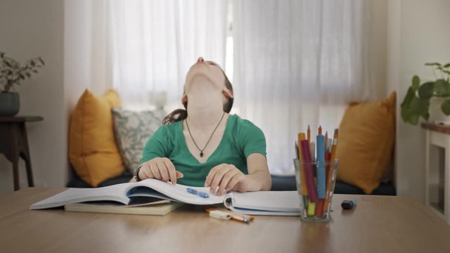 Frustrated teen girl trying and failing to prepare homework for school