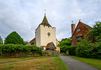 St Bartholomew's Church in Otford, Kent, UK. The church has a square tower with a clock and spire....