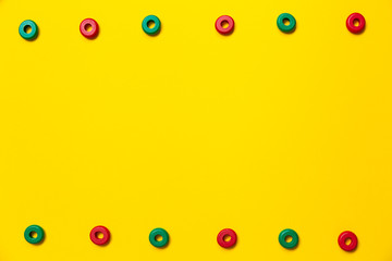 On a yellow background, there are rings of green and red colors of the same size, which form a frame on children's education and development. Backdrop for placing text and other information