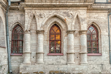 Fototapeta na wymiar arched windows with bars in an old church building in gothic style close up