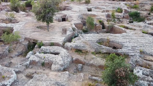 Archeological and necropolis site. Woman is admiring an amazing nature view into a deep creek full of vegetation, Cerveteri, Italy 