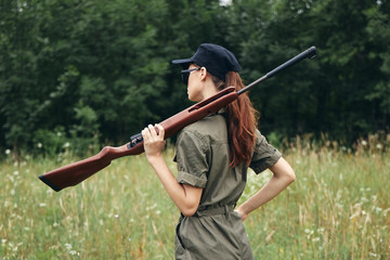 Woman on nature Hunter shotguns walk fresh air green leaves 