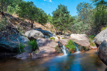 Naklejka na ściany i meble La Pedriza National Park on the southern slopes of the Guadarrama mountain range in Madrid, with cascades. It is one of the largest granitic ranges. It has amazing nature and plenty of leisure options