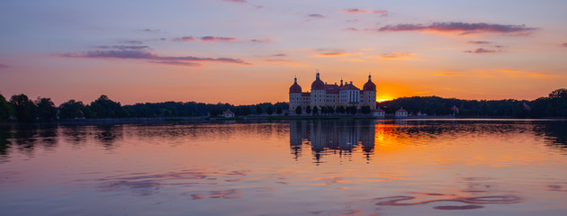 Beautiful evening panorama of Moritzburg Baroque palace surrounded by a lake.