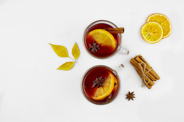 Mulled wine with slice of orange and spices on white  background, top view. Autumn drink or...
