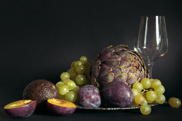 Still life with artichokes, grapes and plums.