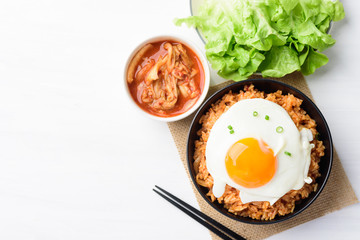 Korean food, Kimchi fried rice with fried egg in a bowl on white table