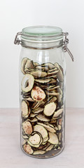 Dry zucchini slices with chili flakes spice in glass jar. Healthy vegetable chips storage. Spicy snacks.