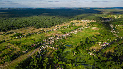 Fototapeta premium Aerial view from drone of beautiful countryside with clouds. Green fields, trees, blue sky.
