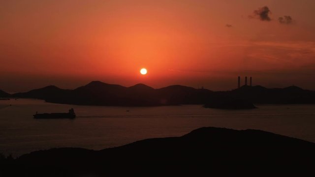 Stunning sunset on Lamma Island power station in Hong Kong - A Cargo Ship passing