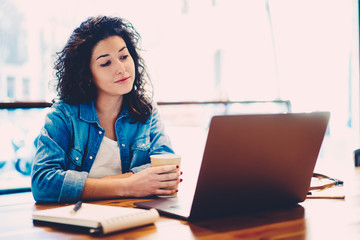Skilled female graphic designer watching useful training webinar in website on laptop computer...
