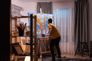 Artist painting on canvas with roller in art workshop. Modern artwork paint on canvas, creative,...
