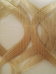 Golden vintage pattern similar to butterfly wings. Gold ribbon on a wooden background.