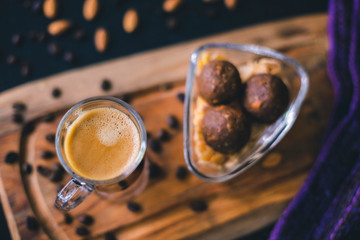 Chocolate peanuts balls with almonds, coffee grains and a cup of coffee