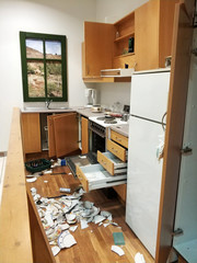 A mess in the kitchen, broken dishes, open cabinets