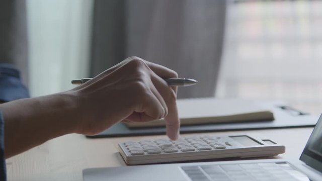 Hand of a businesswoman using a calculator working from home Close-up