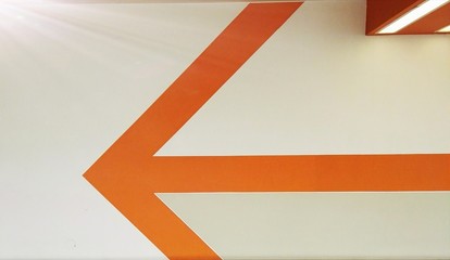 Red and white arrow. Red pointer on left. Sign. Pointer of direction. Orange symbol in a center with geometrical corners. Background for a front-rank row.